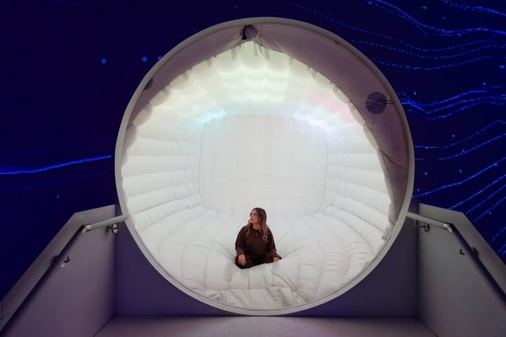 Woman sits inside a glowing circular structure.