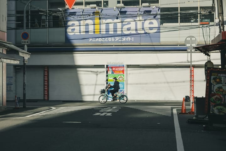 Person rides bicycle past animate store